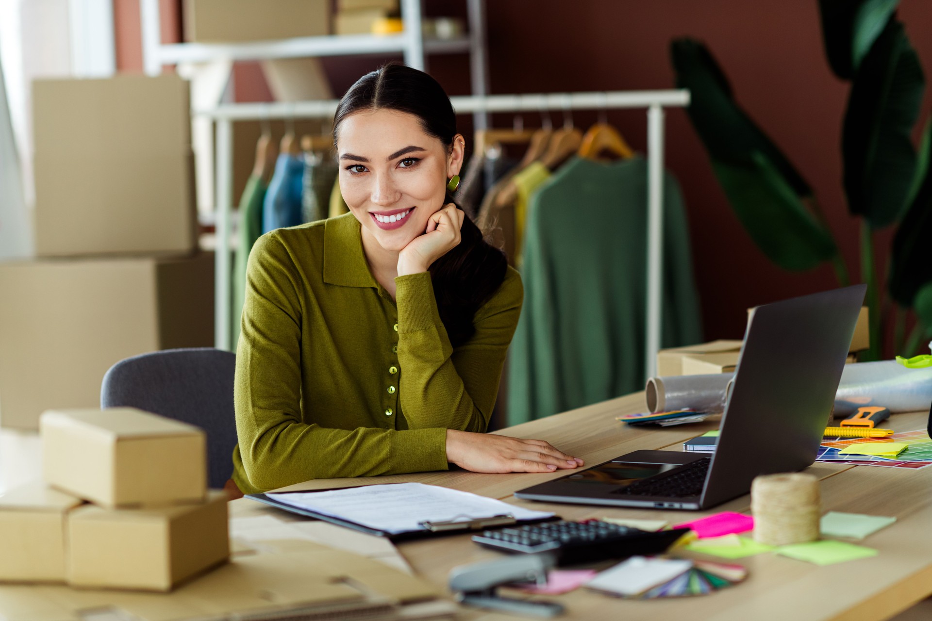 Young entrepreneur working in an organized workspace with fashion highlights, showcasing creativity and modern business adaptability