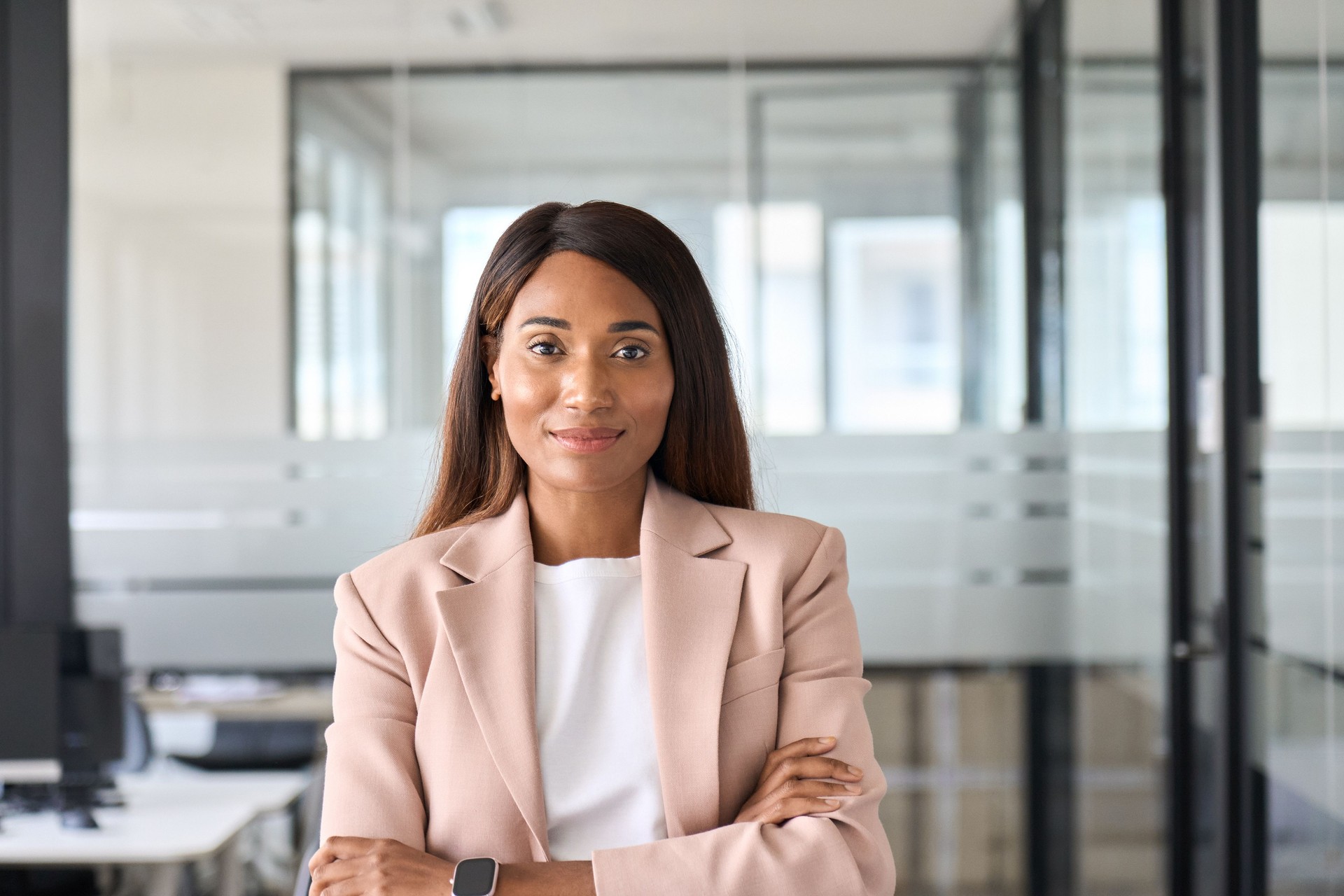 Confident young business woman standing in office, headshot portrait.